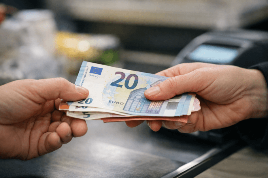 Pérdida de poder adquisitivo reflejada en un pago en efectivo con euros durante una transacción cotidiana.